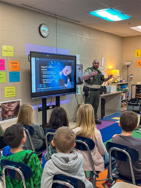 police officer talking to class of students